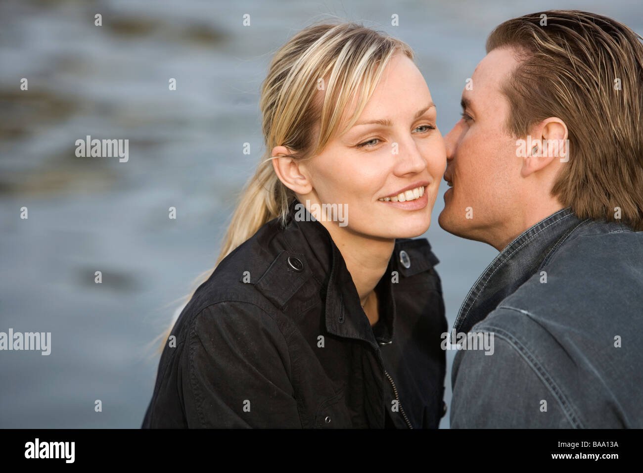 Une femme homme chuchotant à l'oreille', Stockholm, Suède. Banque D'Images