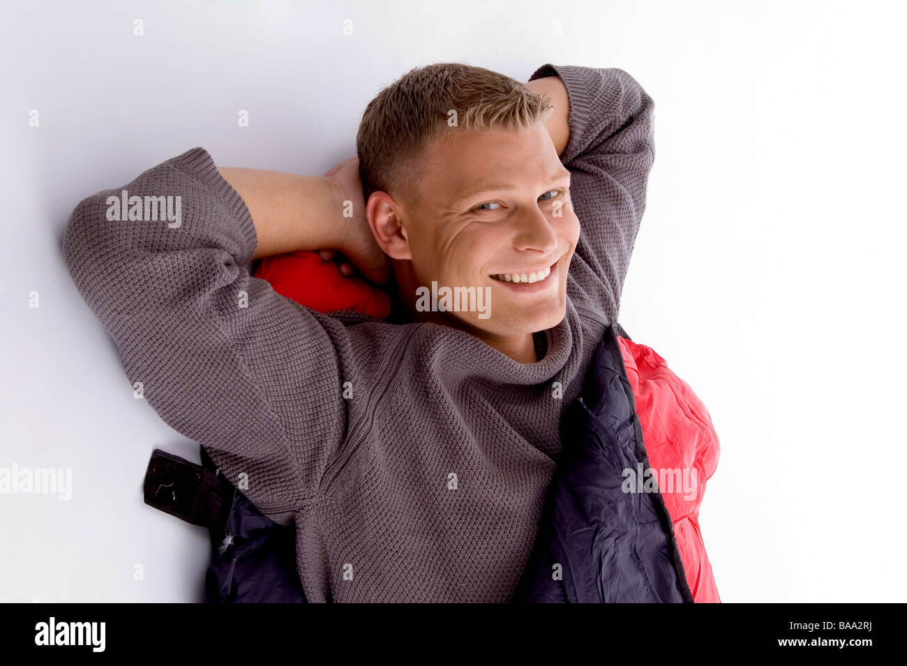 Smiling young guy posant dans sac de couchage Banque D'Images