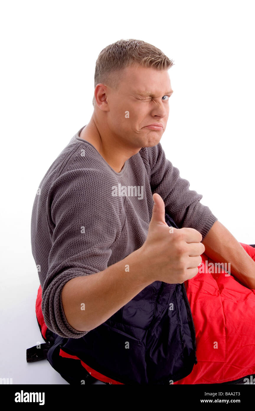 Jeune mec avec Thumbs up et dans sac de couchage Banque D'Images