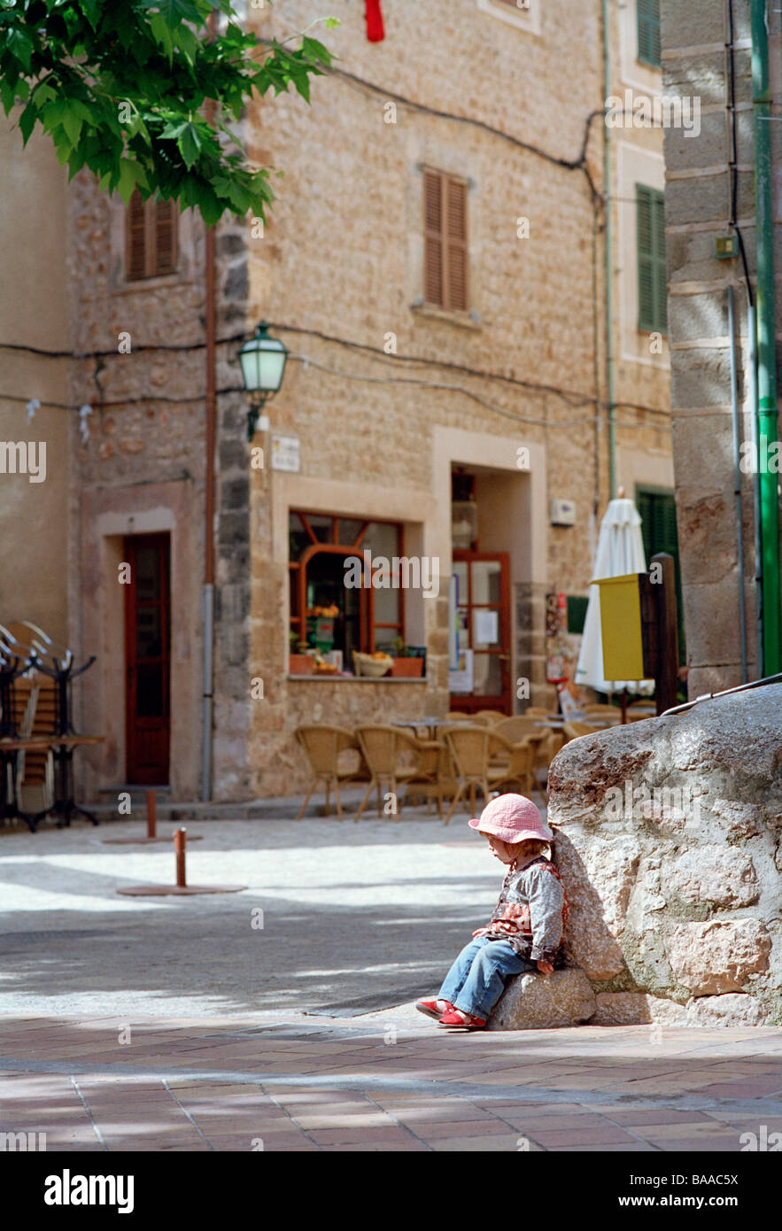 Un enfant assis sur un rocher, à Majorque. Banque D'Images