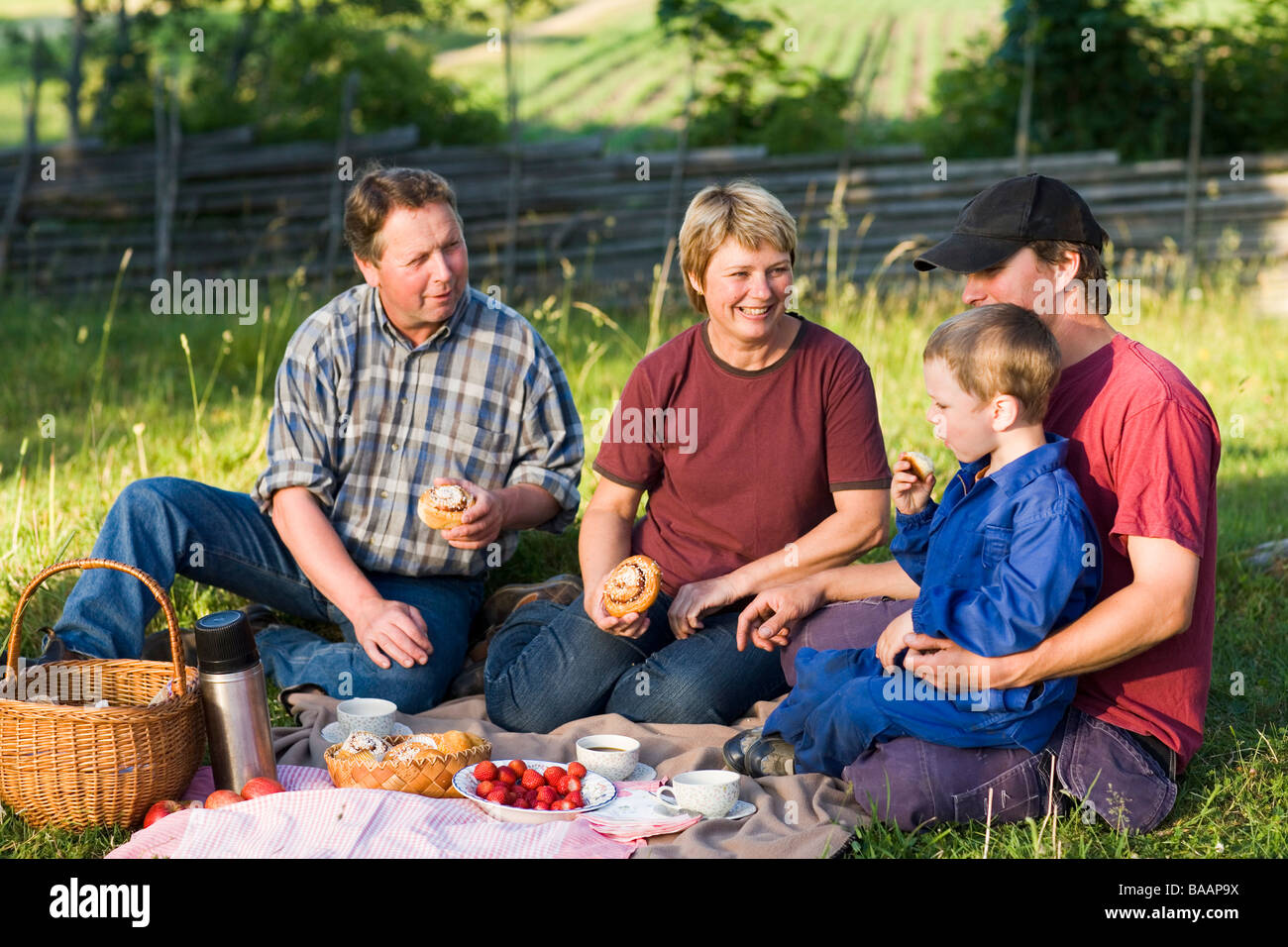 Une famille d'agriculteurs en prenant une pause dans l'herbe, la Suède. Banque D'Images