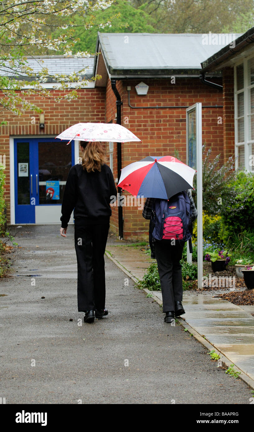 Enfants à l'école à pied sous la pluie Banque D'Images