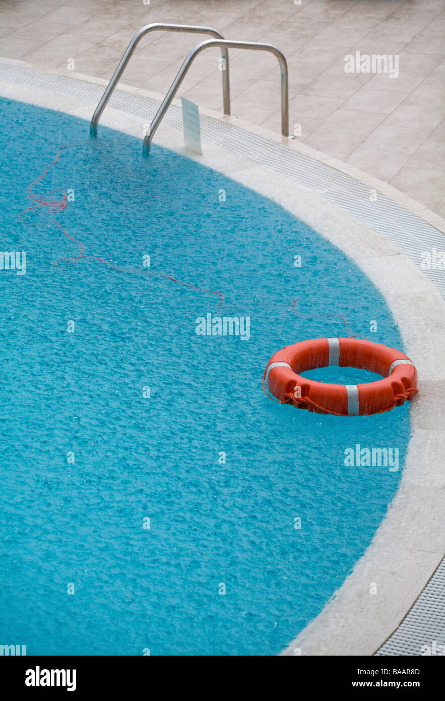 La courroie de la vie dans une piscine sous la pluie Banque D'Images