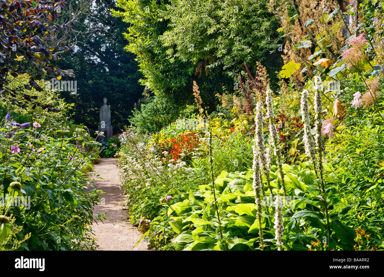 Chemin de jardin entre plante herbacée vivace des frontières pour conduire à une statue à Wheatley Oxfordshire Oxon Waterperry Gardens England UK Banque D'Images