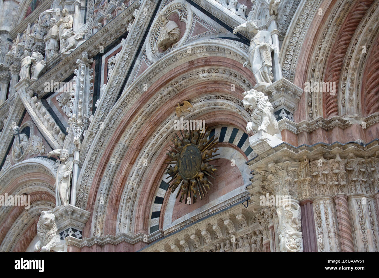 Marbre sculpté des chiffres sur la façade du Duomo (cathédrale) à partir de la Piazza del Duomo, Sienne, Toscane, Italie. Banque D'Images