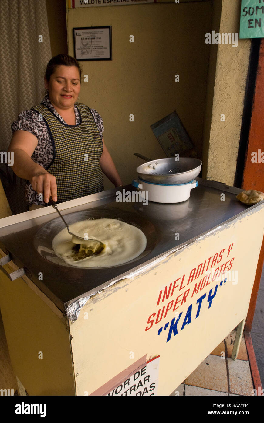 Femme infladitas la cuisine mexicaine semoule dans l'huile chaude dans un petit restaurant. Puebla, Mexique Banque D'Images