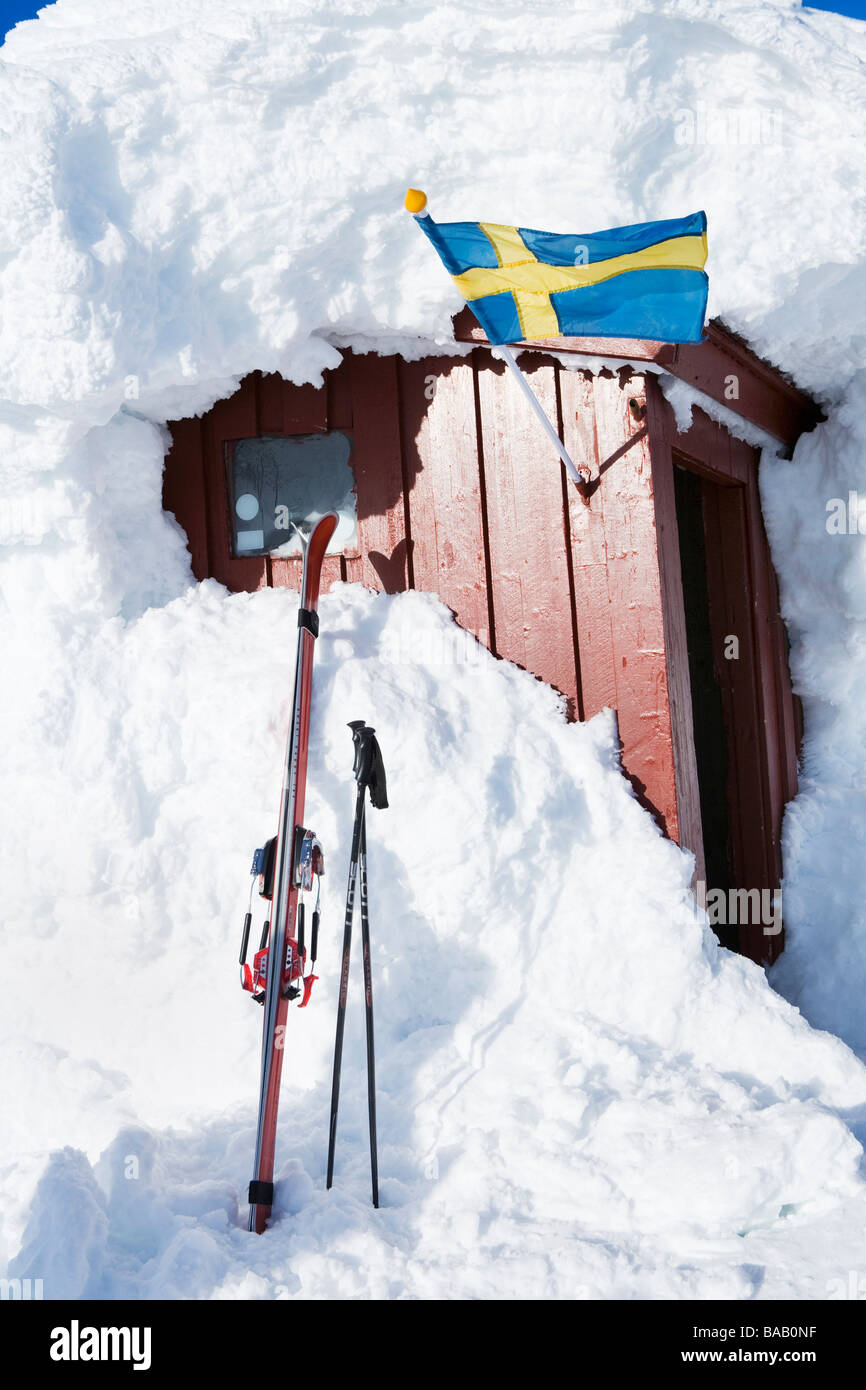 Un drapeau suédois sur une petite maison couverte de neige, la Suède. Banque D'Images