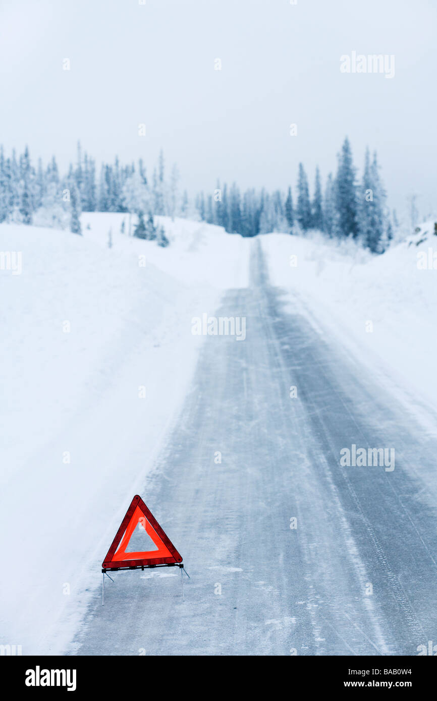Un triangle d'avertissement sur une route de campagne et l'hiver, la Suède. Banque D'Images
