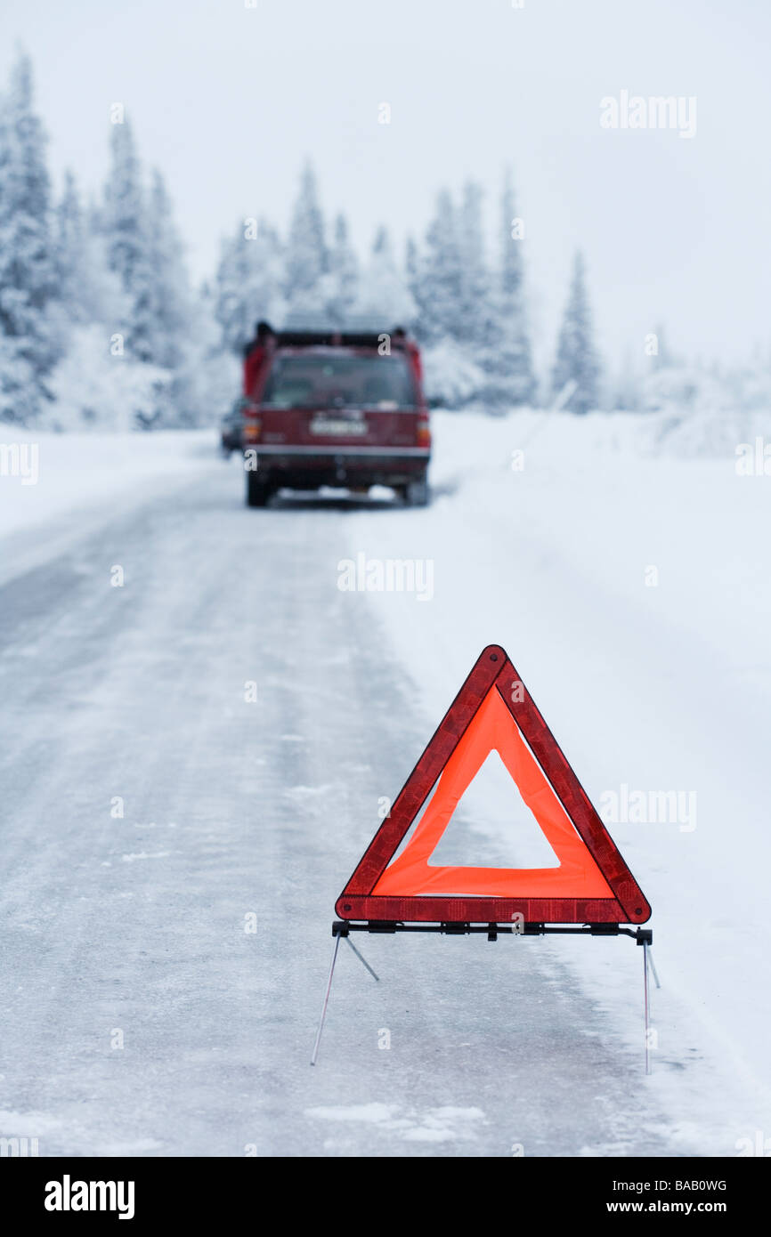 Un triangle d'avertissement sur une route de campagne et l'hiver, la Suède. Banque D'Images
