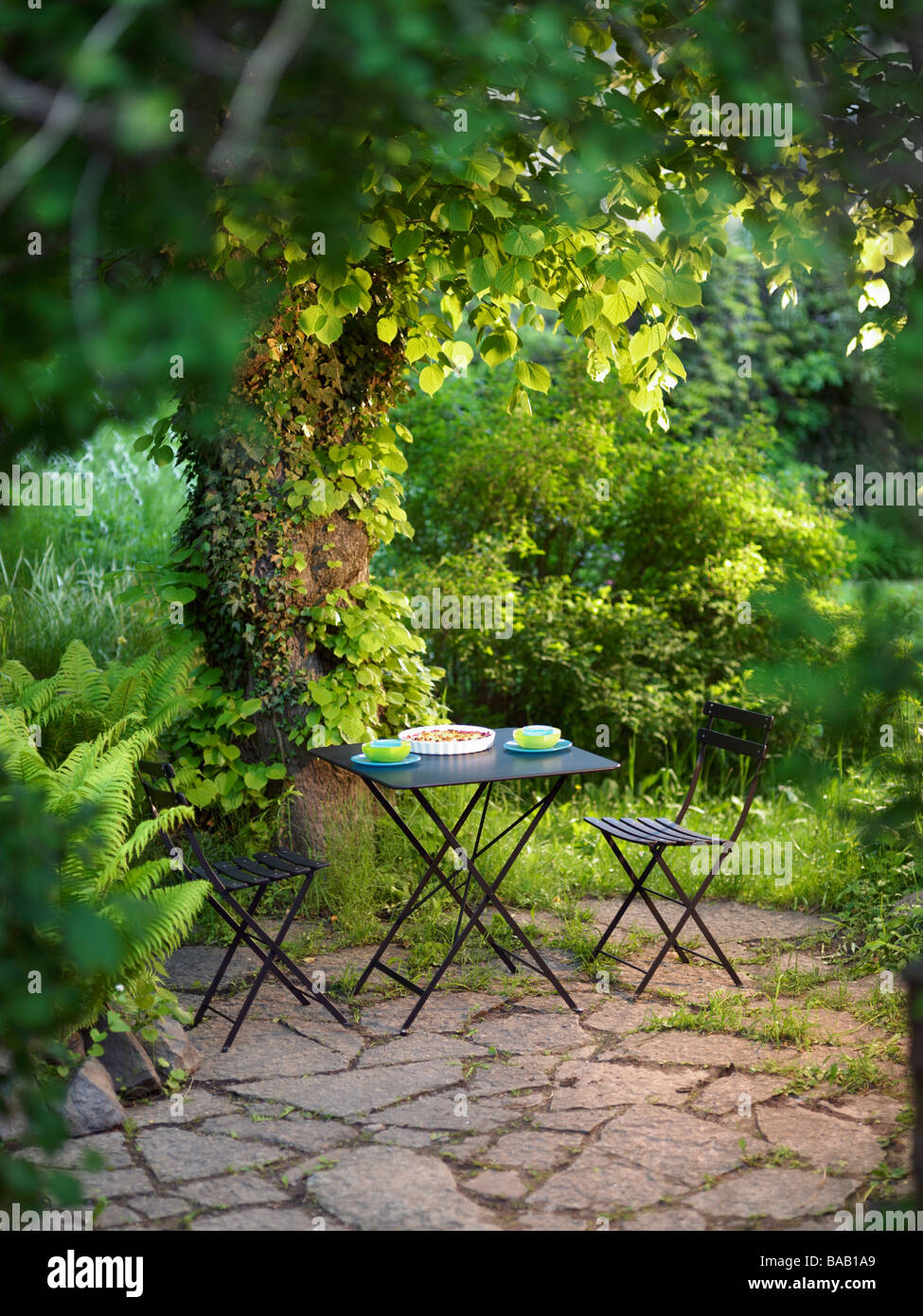 Une table d'extérieur dans un jardin fleuri, la Suède. Banque D'Images