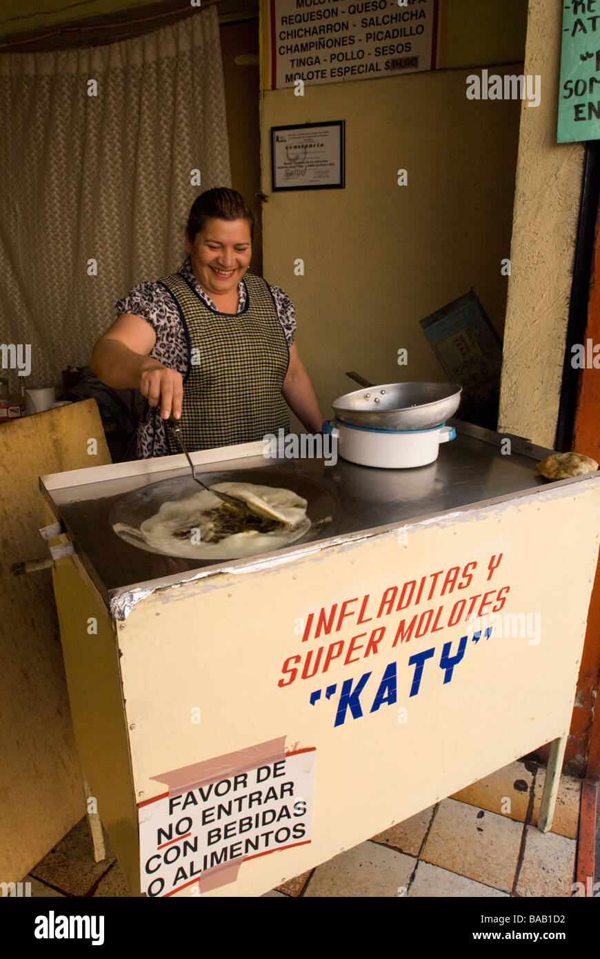 Femme infladitas la cuisine mexicaine semoule dans l'huile chaude dans un petit restaurant. Puebla, Mexique Banque D'Images