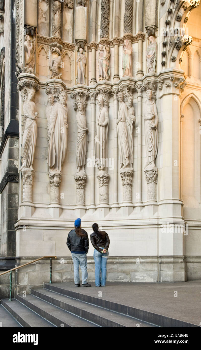 Les visiteurs d'admirer des sculptures sur la façade de la cathédrale de Saint John the Divine à New York City Banque D'Images