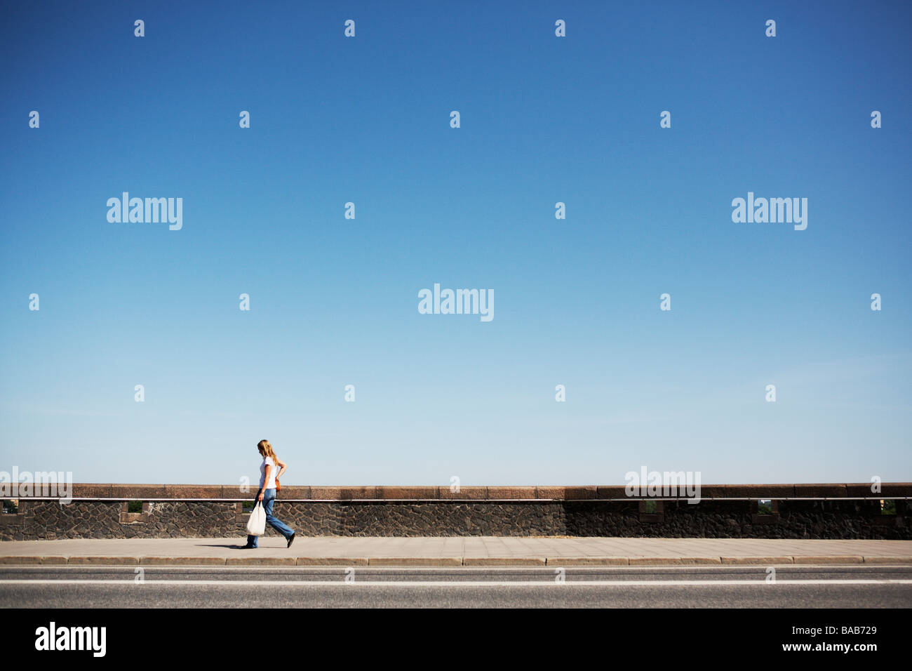 Une femme marche sur le trottoir Photo Stock Alamy