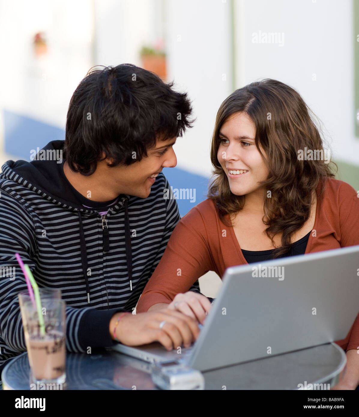 Jeune couple à un café avec un ordinateur portable au Portugal. Banque D'Images