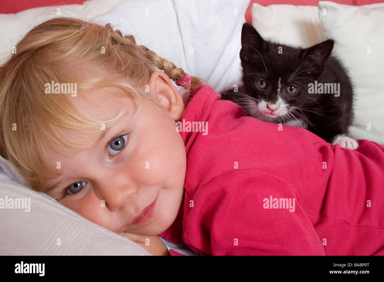 Petite fille jouant avec des tout-petits chaton noir Banque D'Images