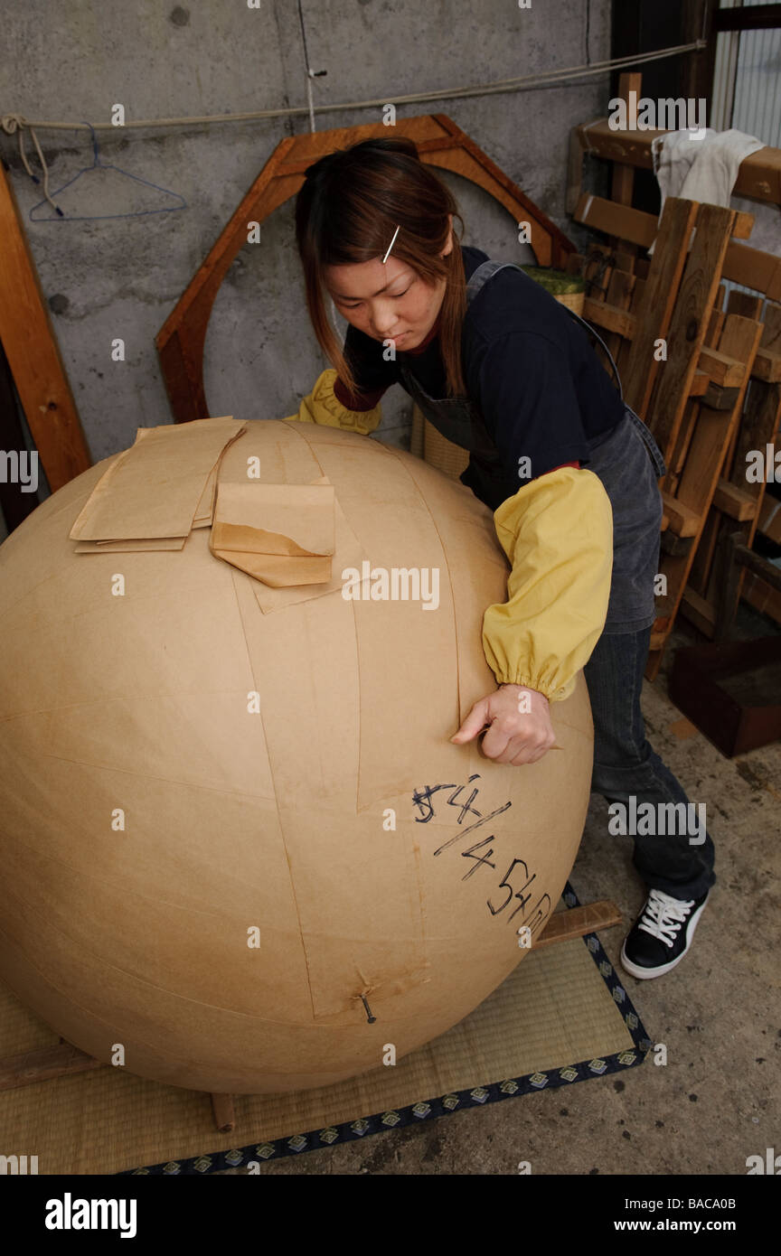 Un travailleur ajoute une couche de papier à un yonshakudama 420kg d'artifice, Katakai Japon, 6 avril 2009. Banque D'Images