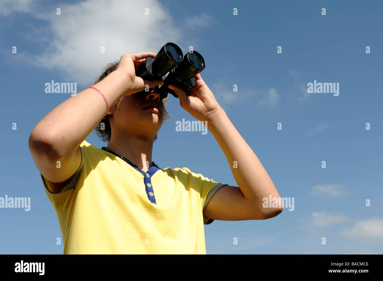 Boy looking through binoculars Banque D'Images