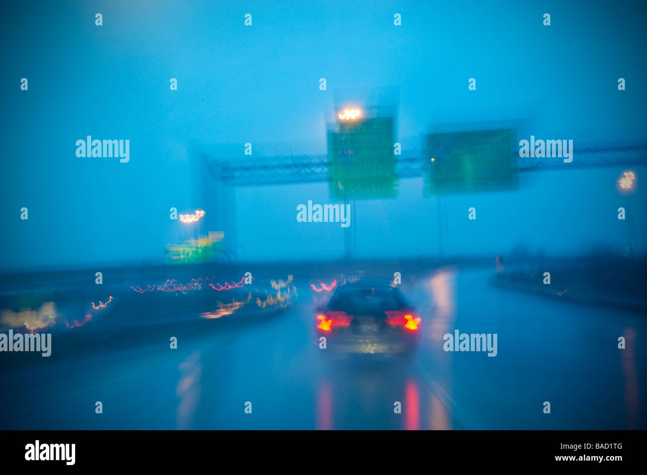 Une voiture sur route mouillée des pluies avec la signalisation routière dans la pluie, Philadelphia, Pennsylvania, USA Banque D'Images