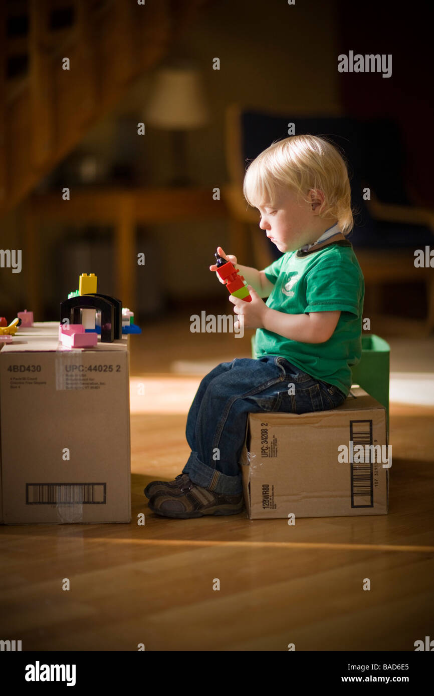 Enfant jouant avec des jouets sur des boîtes de carton Banque D'Images