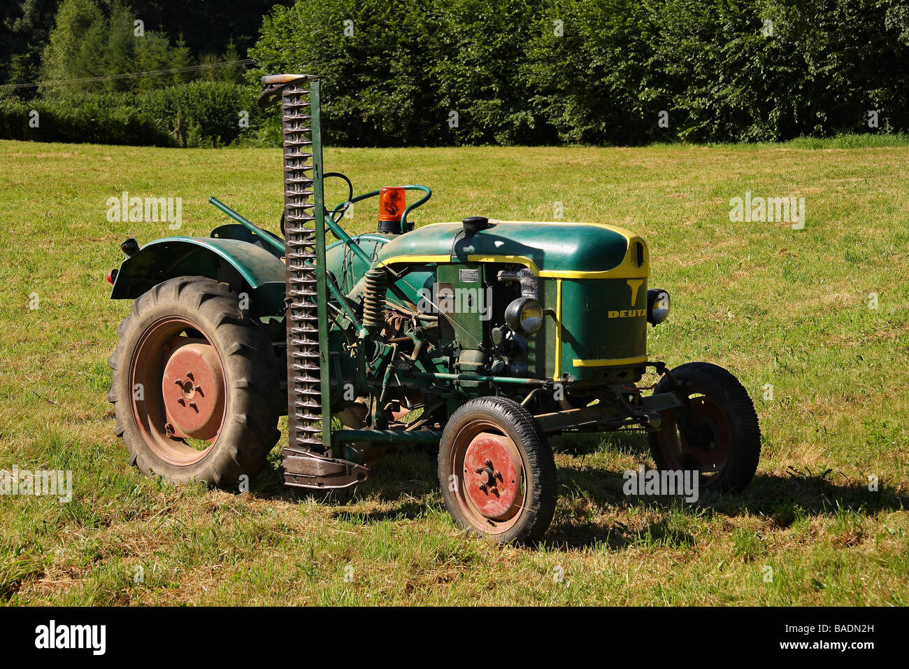 Un livre vert et jaune 1959 Tracteur Deutz F1 monté sur le côté avec la faucheuse d'herbe dans un champ Limousin France Banque D'Images