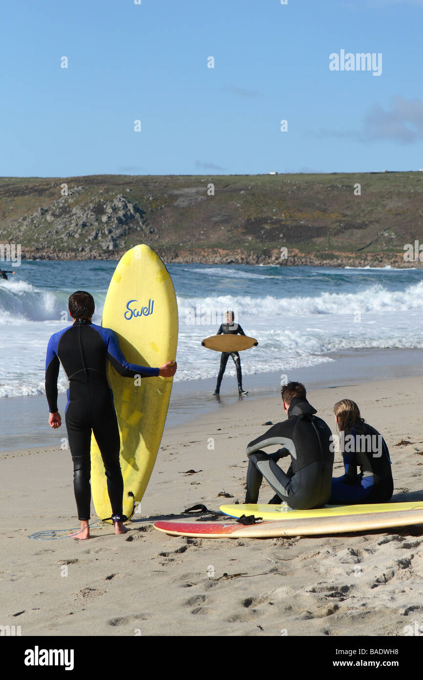 Sennen Cove beach jeunes surfeurs surf Cornwall vous détendre sur la plage de sable Banque D'Images