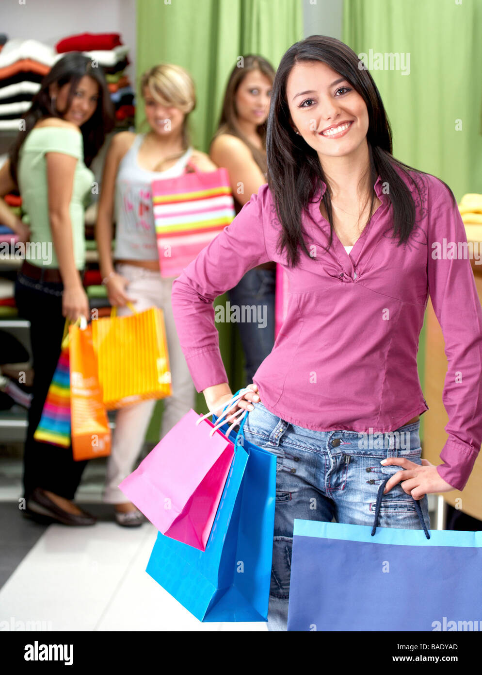 Amis de sexe féminin dans un magasin de détail en souriant et l'achat des vêtements Banque D'Images