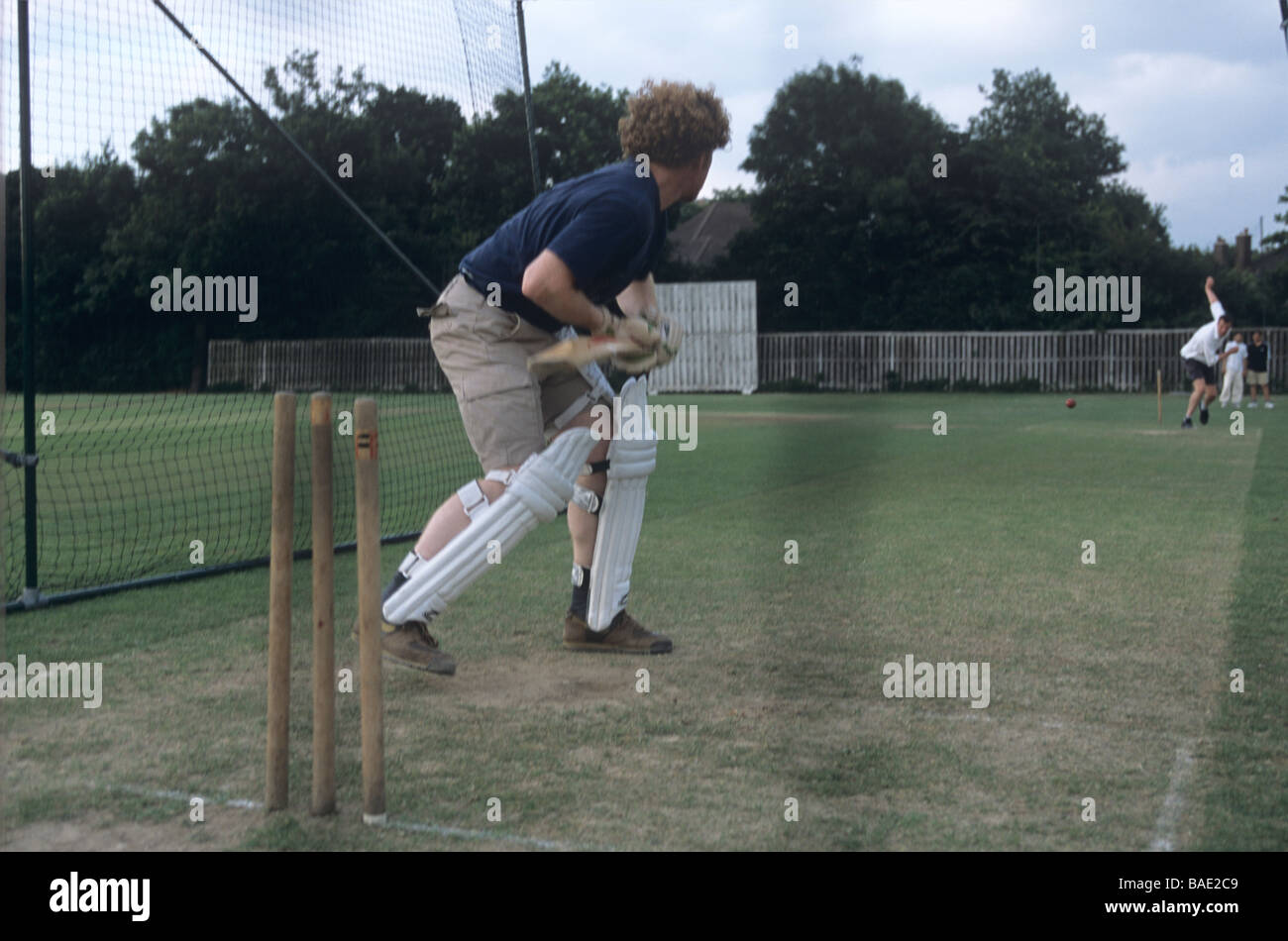 Cricketers exerçant dans les filets de cricket dans le parc 76200 Banque D'Images