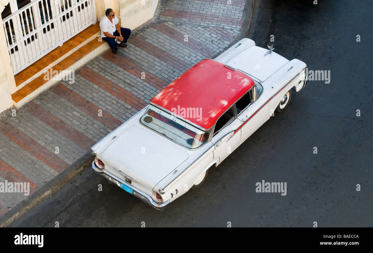 Vue aérienne d'une voiture d'époque dans les rues de Santiago de Cuba avec un homme à la recherche sur Banque D'Images Vue aérienne d'une voiture d'époque dans les rues de Santiago de Cuba avec un homme à la recherche sur Banque D'Images