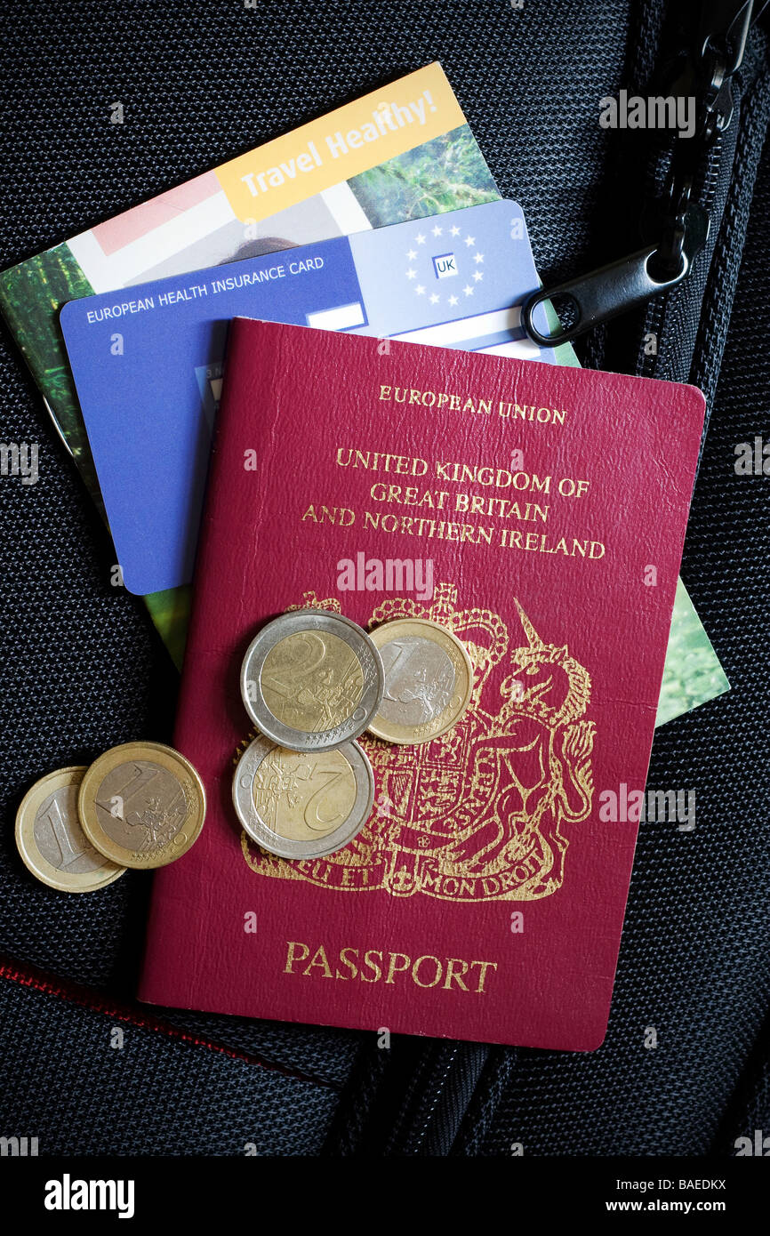 Close up d'un passeport britannique, CEAM carte santé et certaines devises étrangères assis sur le dessus d'une valise Banque D'Images