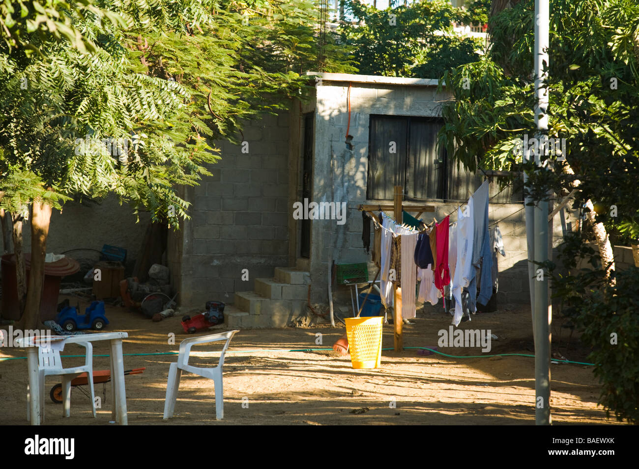 Mexique La Playita denim jeans et les vêtements accrochés sur une corde à linge à sécher dans la cour avant du bloc de béton Banque D'Images