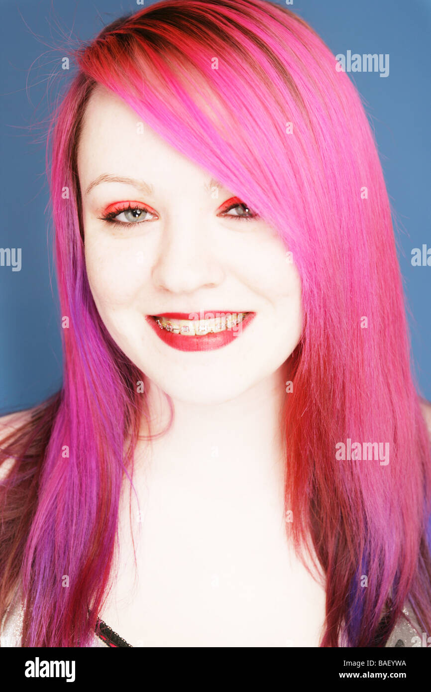 Jeune adolescente goth avec des cheveux roses portant des accolades smiling at camera. Banque D'Images
