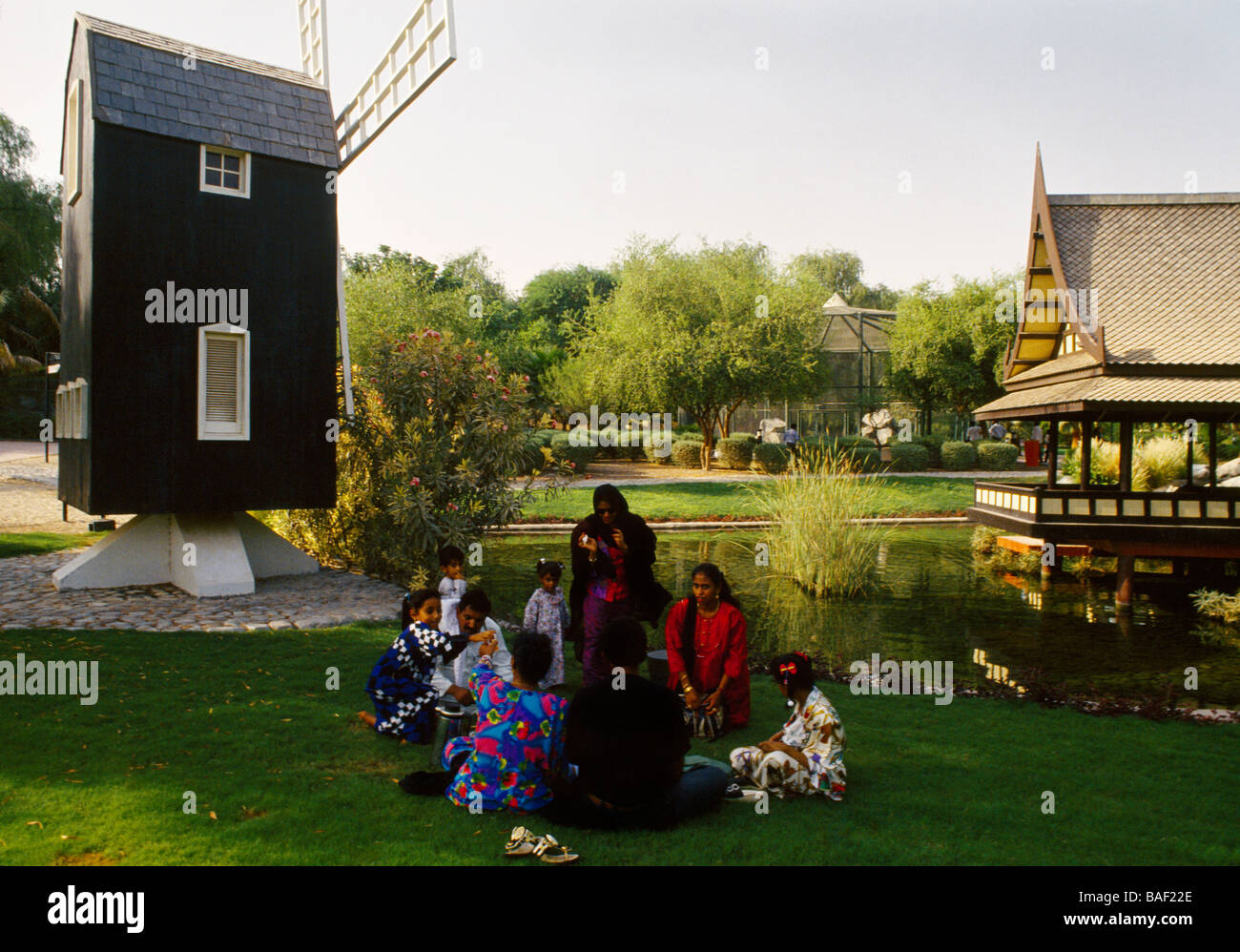Mushrif Park Dubai UAE International Village femmes ayant Un pique-nique voilé et dévoilé par le Moulin de Hollande et la maison thaïlandaise à International Villag Banque D'Images