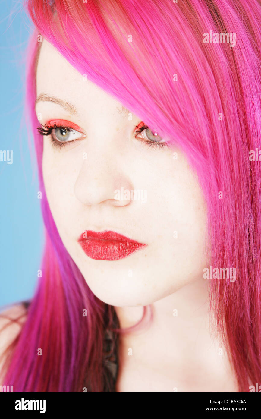 Head shot of a dix-huit ans avec goth cyber peau pâle et les cheveux rouges et rouge à lèvres Banque D'Images