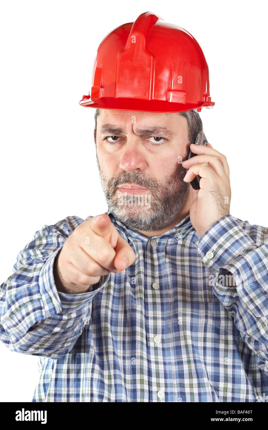 La colère des travailleurs de la construction avec un casque tout en parlant avec téléphone isolé sur fond blanc les yeux sur l'accent Banque D'Images
