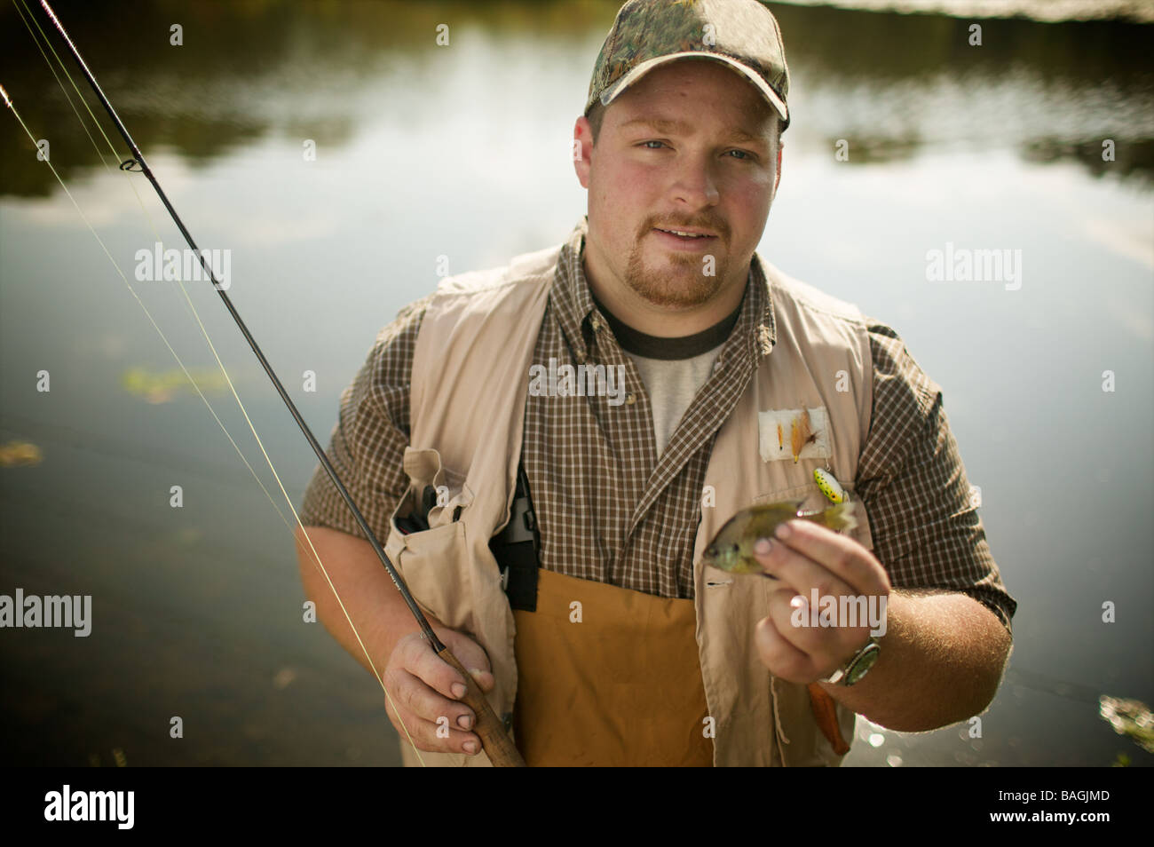 Caucasian fisherman semble un peu dubitatif quant à ses prises de la journée. Quelle est la limite ? Non non, il s'agit d'appât ! Banque D'Images