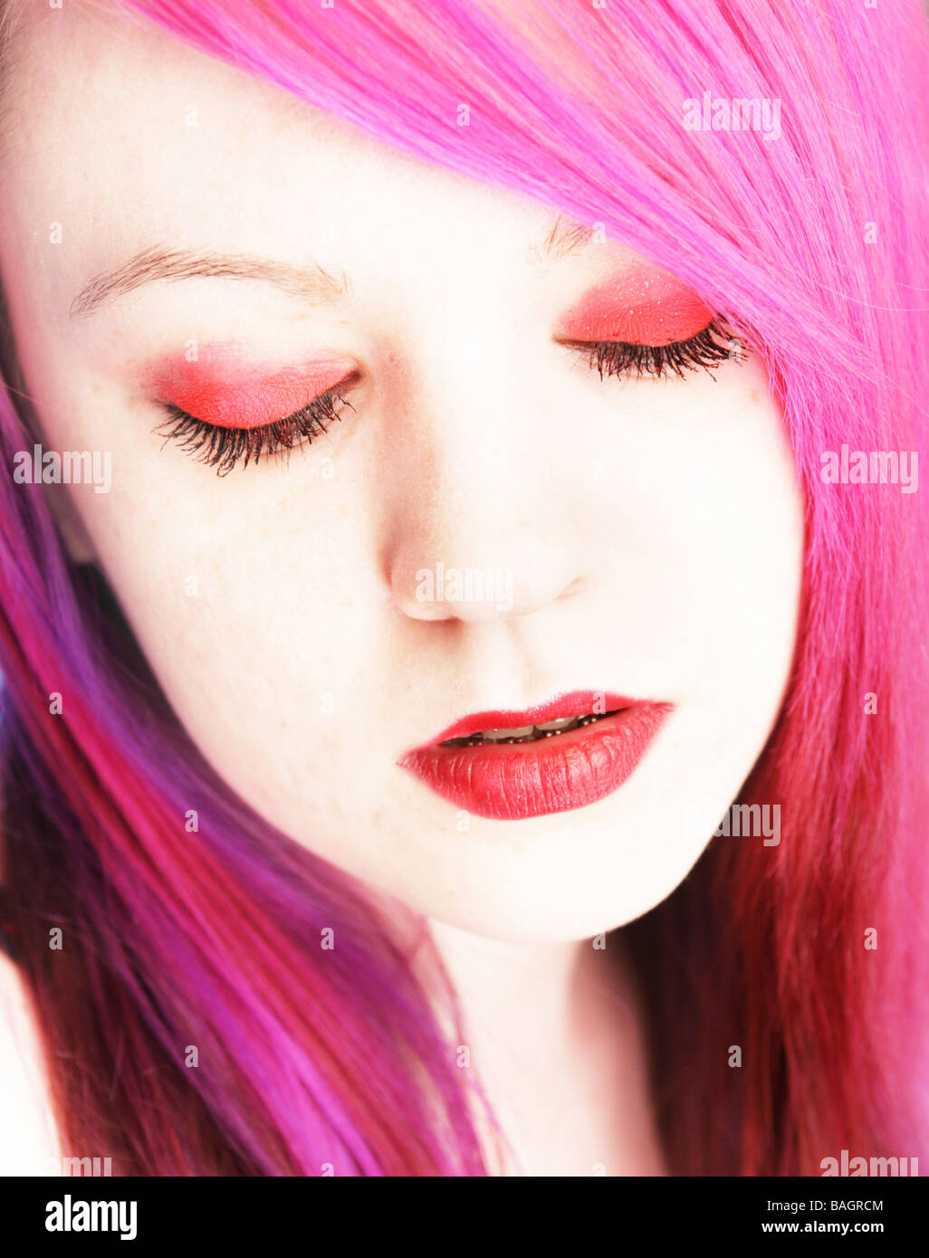 Close up d'une alternative à la teen avec des cheveux roses et des lèvres rouges et la peau pâle Banque D'Images