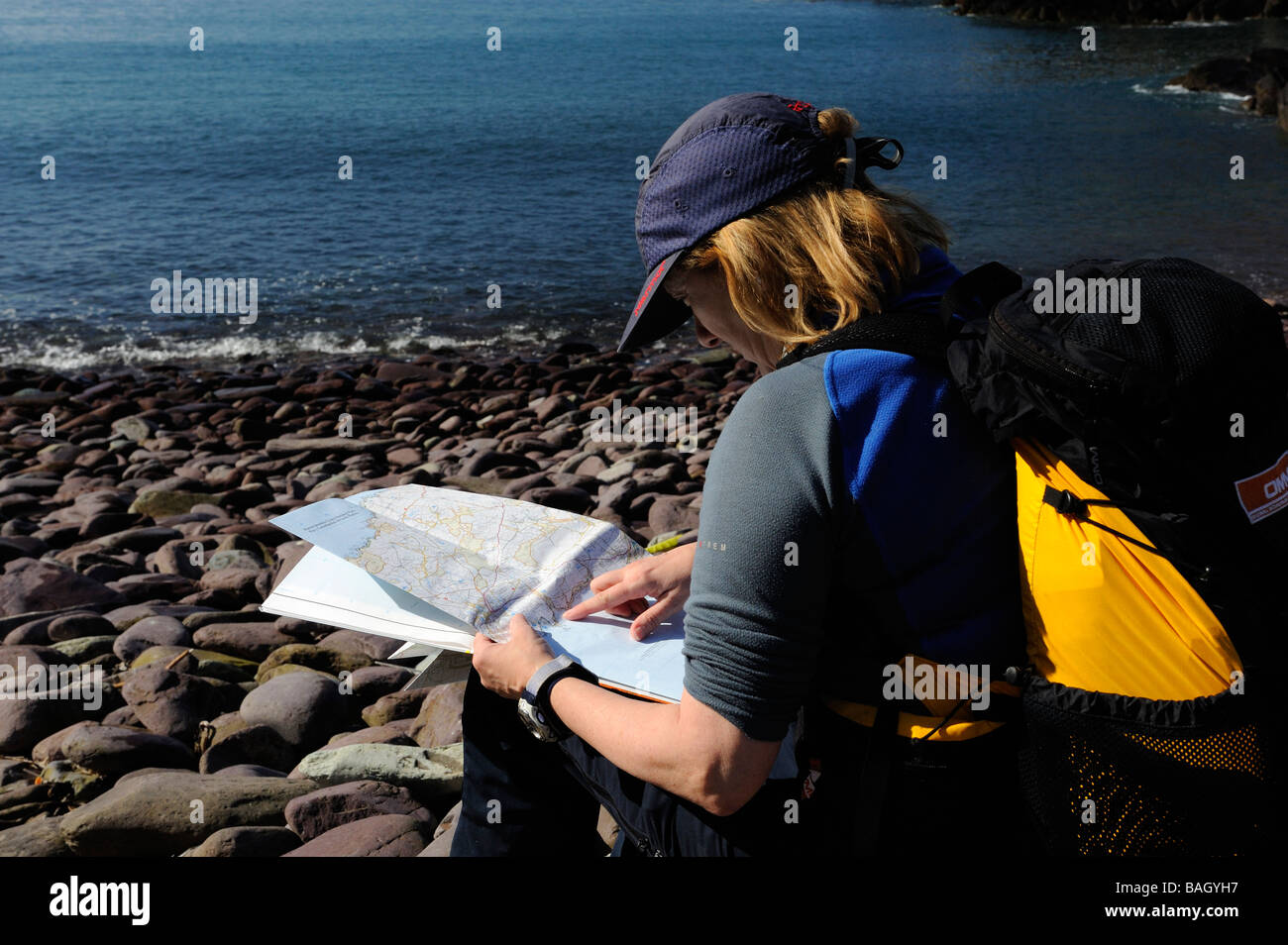 Femme walker reading a map et contrôler la route alors que le sentier côtier du Pembrokeshire Banque D'Images