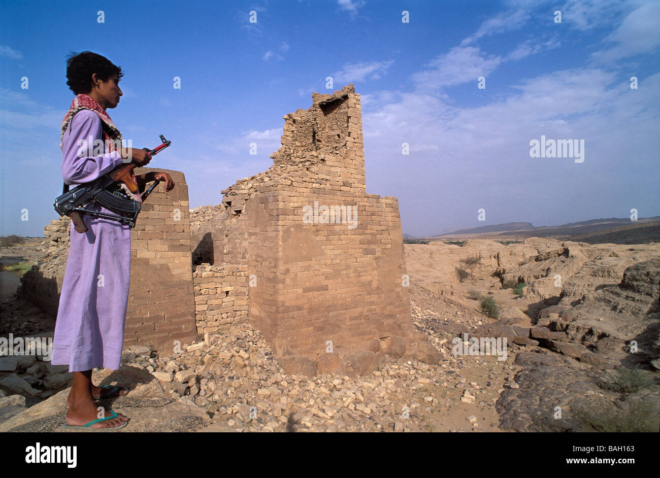 Au Yémen, le gouvernorat de Marib, Marib, blocage du nord, ancien barrage, l'homme avec l'arme Banque D'Images