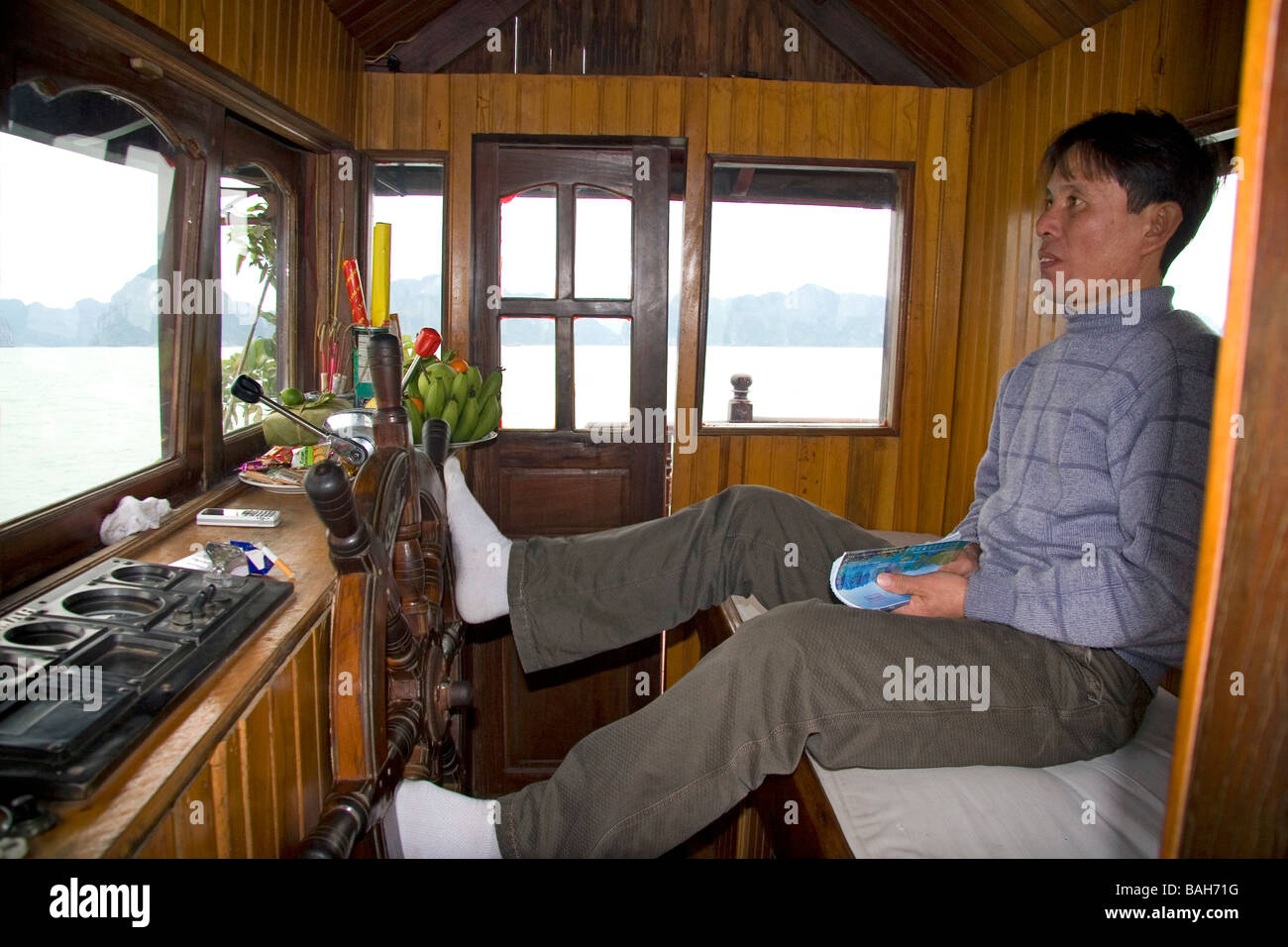 Capitaine de bateau vietnamien de la direction avec ses pieds en Baie d'Ha Long Vietnam Banque D'Images