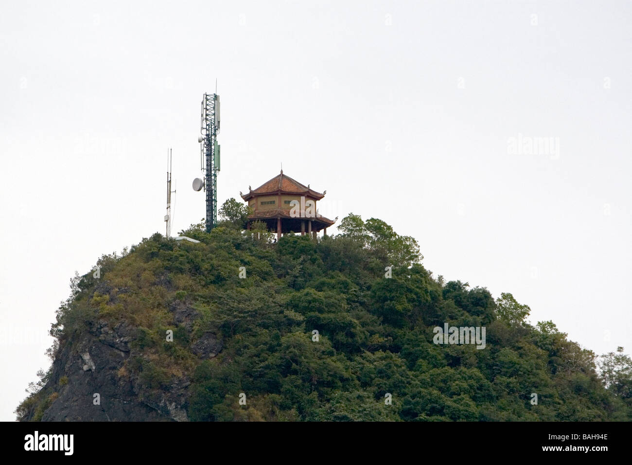 Karast calcaire surmonté d'une structure ancienne et moderne de la tour de téléphonie cellulaire en Baie d'Ha Long Vietnam Banque D'Images