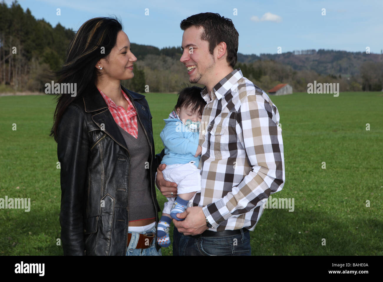 Une jeune famille heureuse avec leur fils âgé de 4 mois Banque D'Images