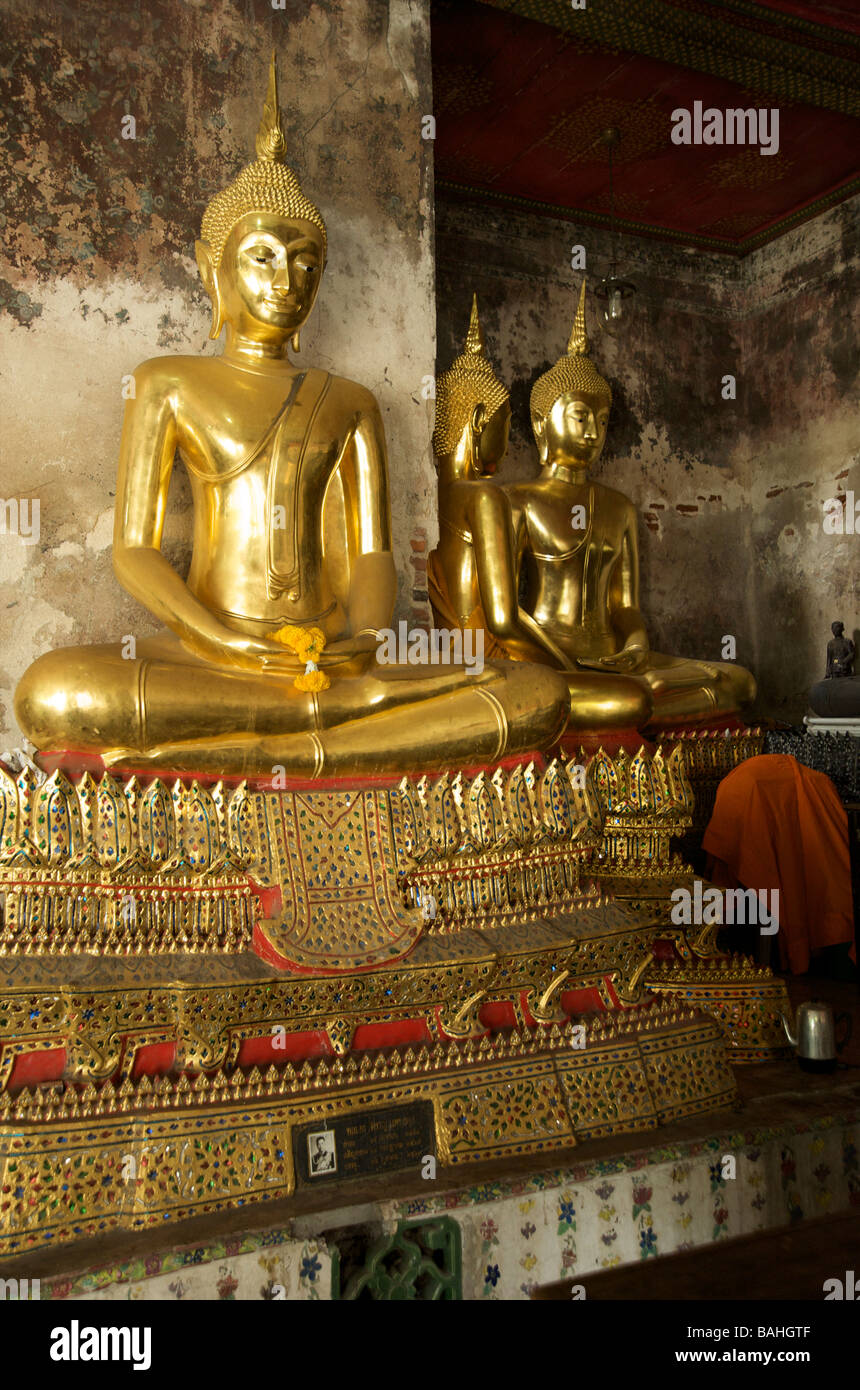 Statues de Bouddha en or la ligne galeries qui entourent le bâtiment principal contenant des Bouddhas de Wat Suthat à Bangkok en Thaïlande Banque D'Images