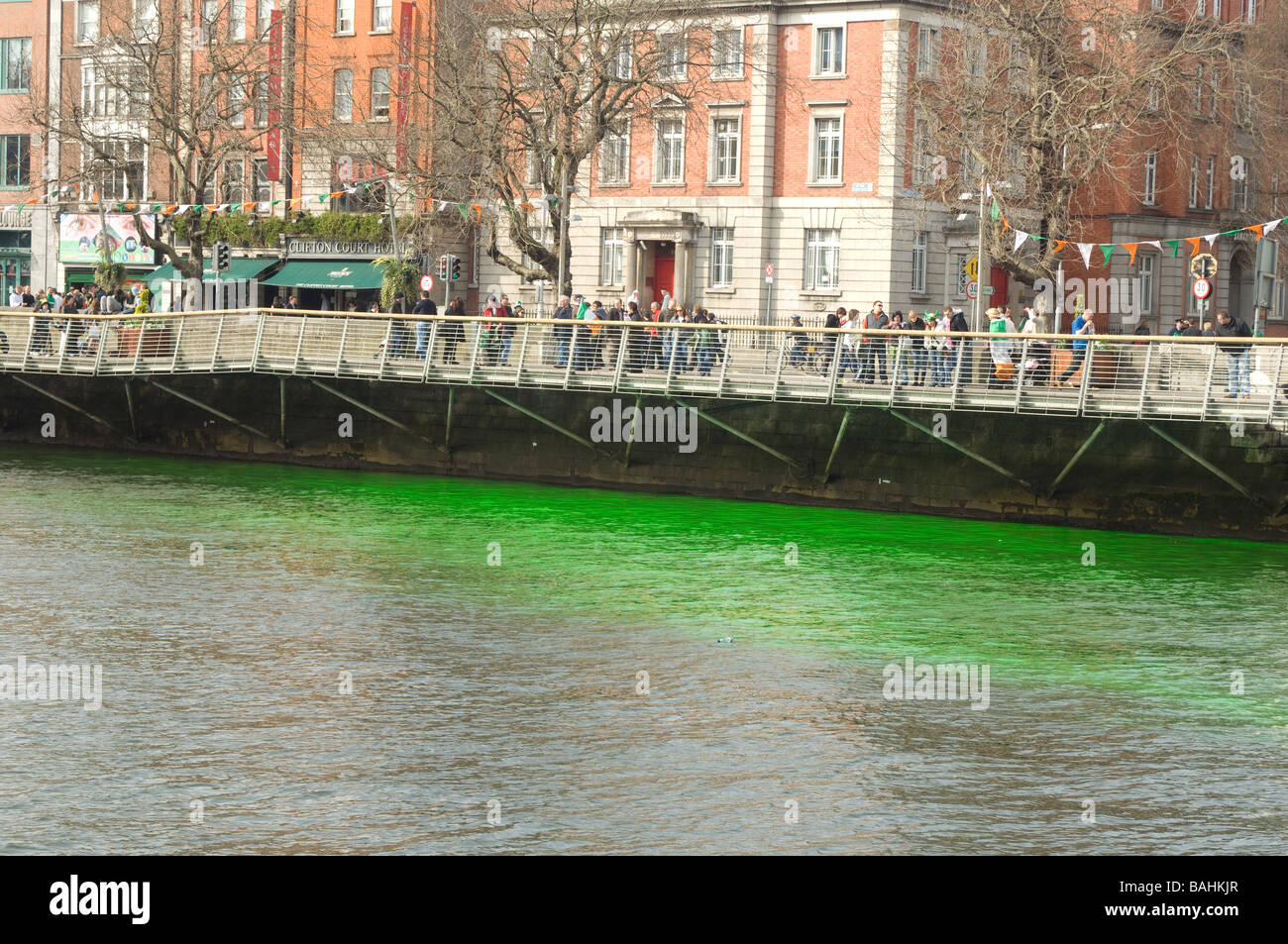 La foule célébrant au bord de la rivière Liffey et teint en vert sur St Patrick's day, Dublin, Irlande Banque D'Images