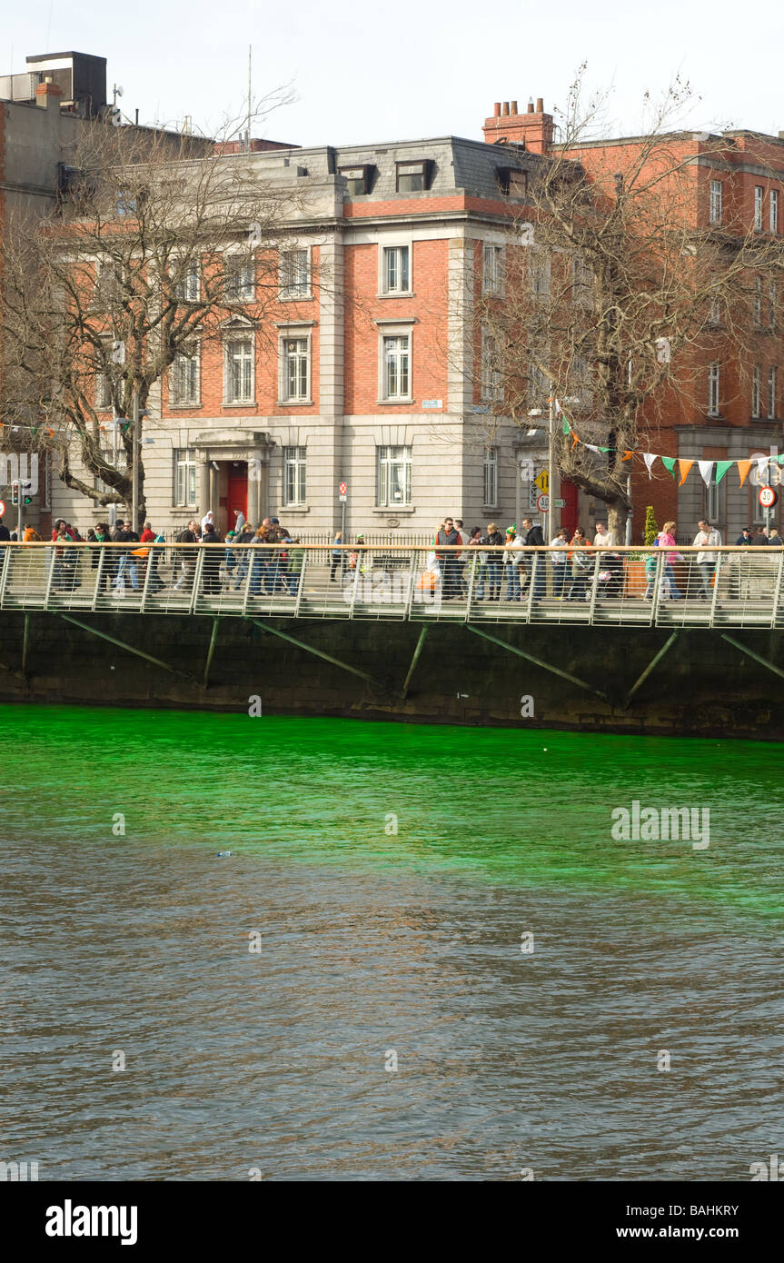 La foule célébrant au bord de la rivière Liffey et teint en vert sur St Patrick's day, Dublin, Irlande Banque D'Images