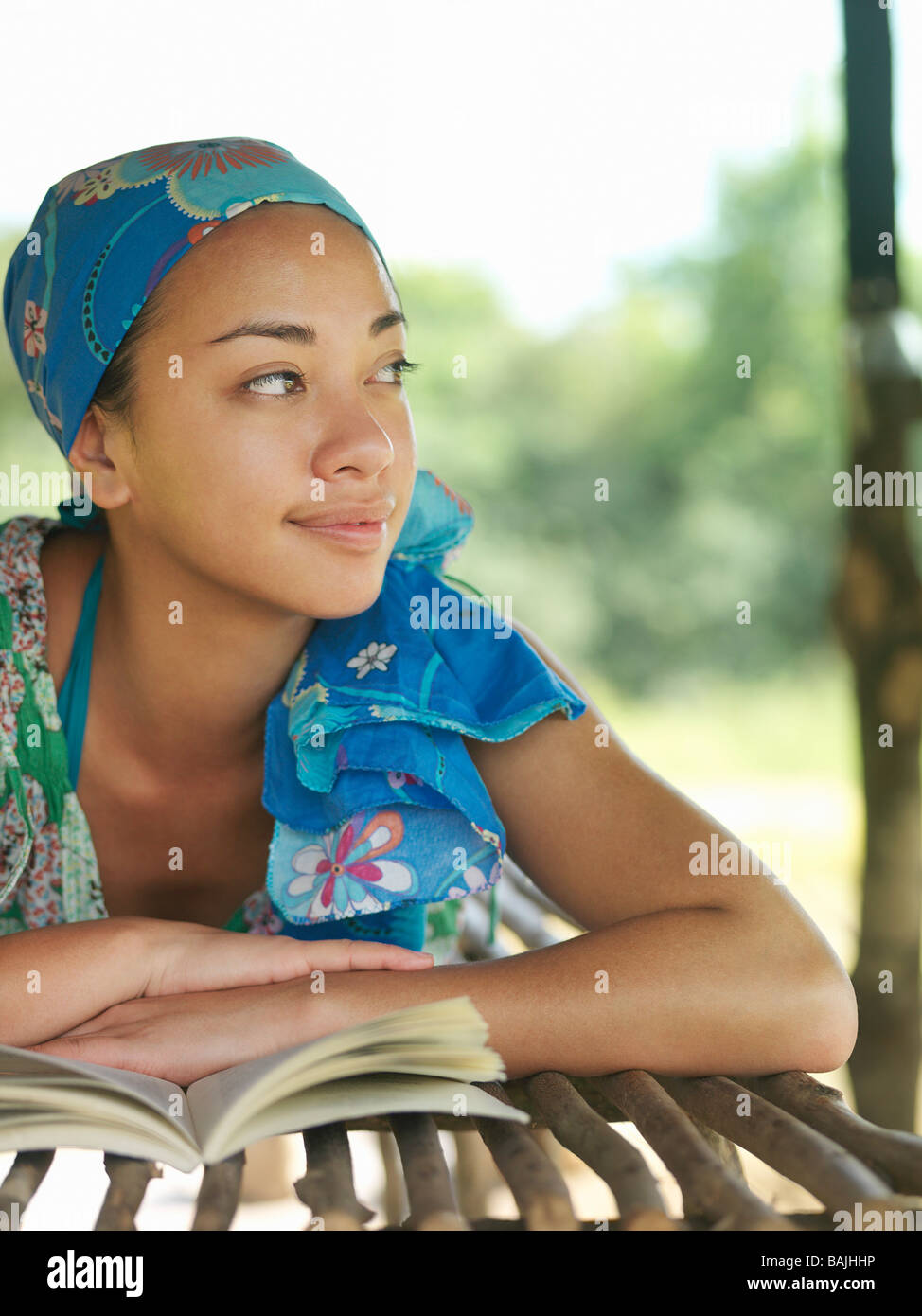 Portrait de jeune femme portant foulard, couchant avec réserve en hut, couchée, smiling Banque D'Images