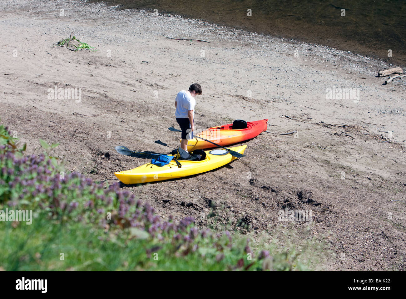 Kayaks et jeune homme sur la plage à la Delaware Water Gap dans le New Jersey. Banque D'Images