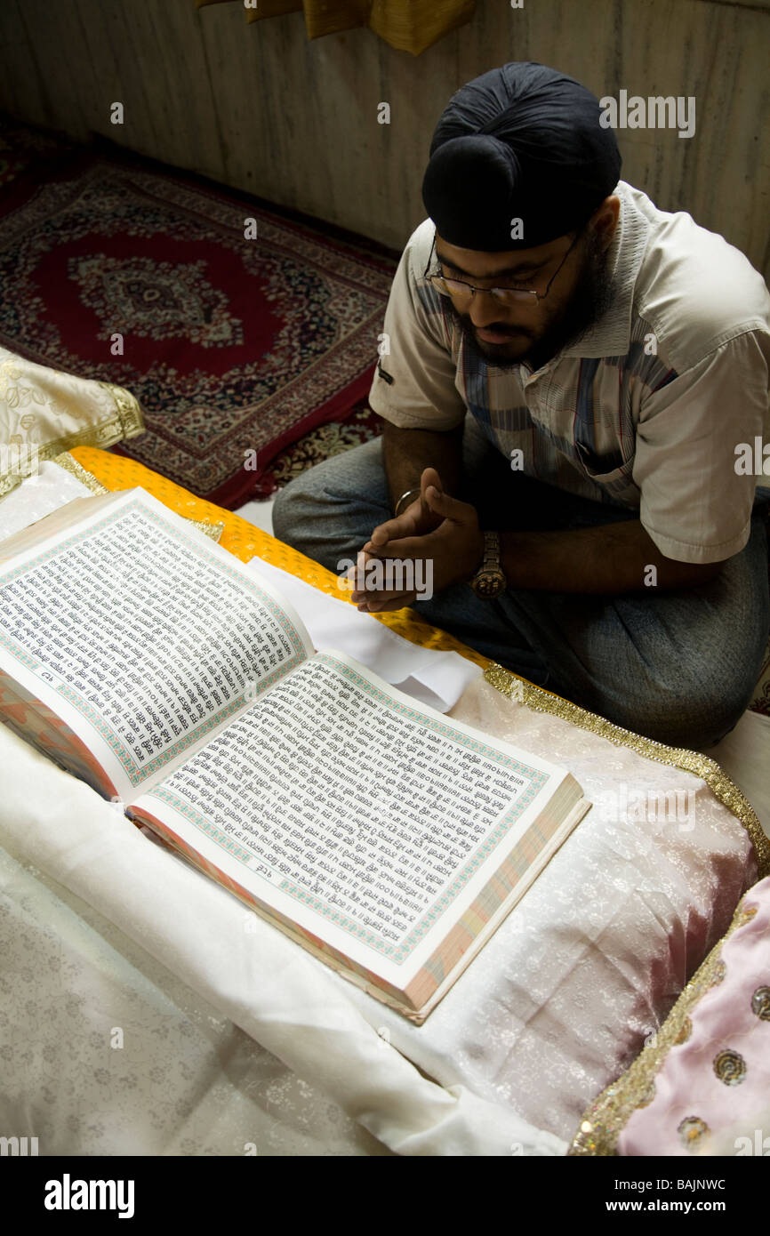 Un sikh lit depuis le Guru Granth Sahib, ou de l'IDA Le Sri Guru Granth Sahib : la sainte Écriture et le dernier gourou des sikhs. Banque D'Images