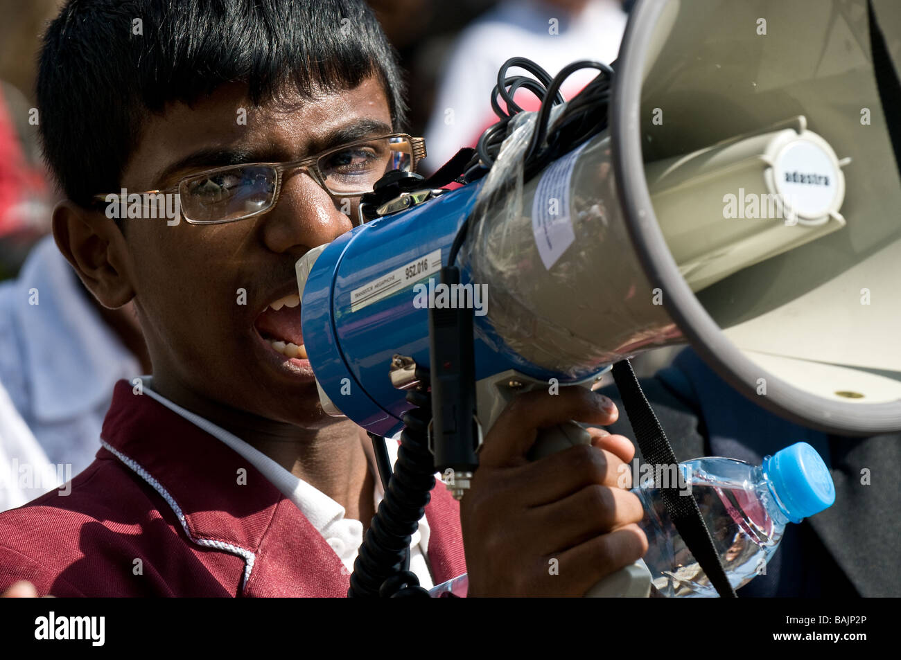 Un étudiant tamoul criant des slogans dans un mégaphone lors d'une manifestation à Londres. Banque D'Images