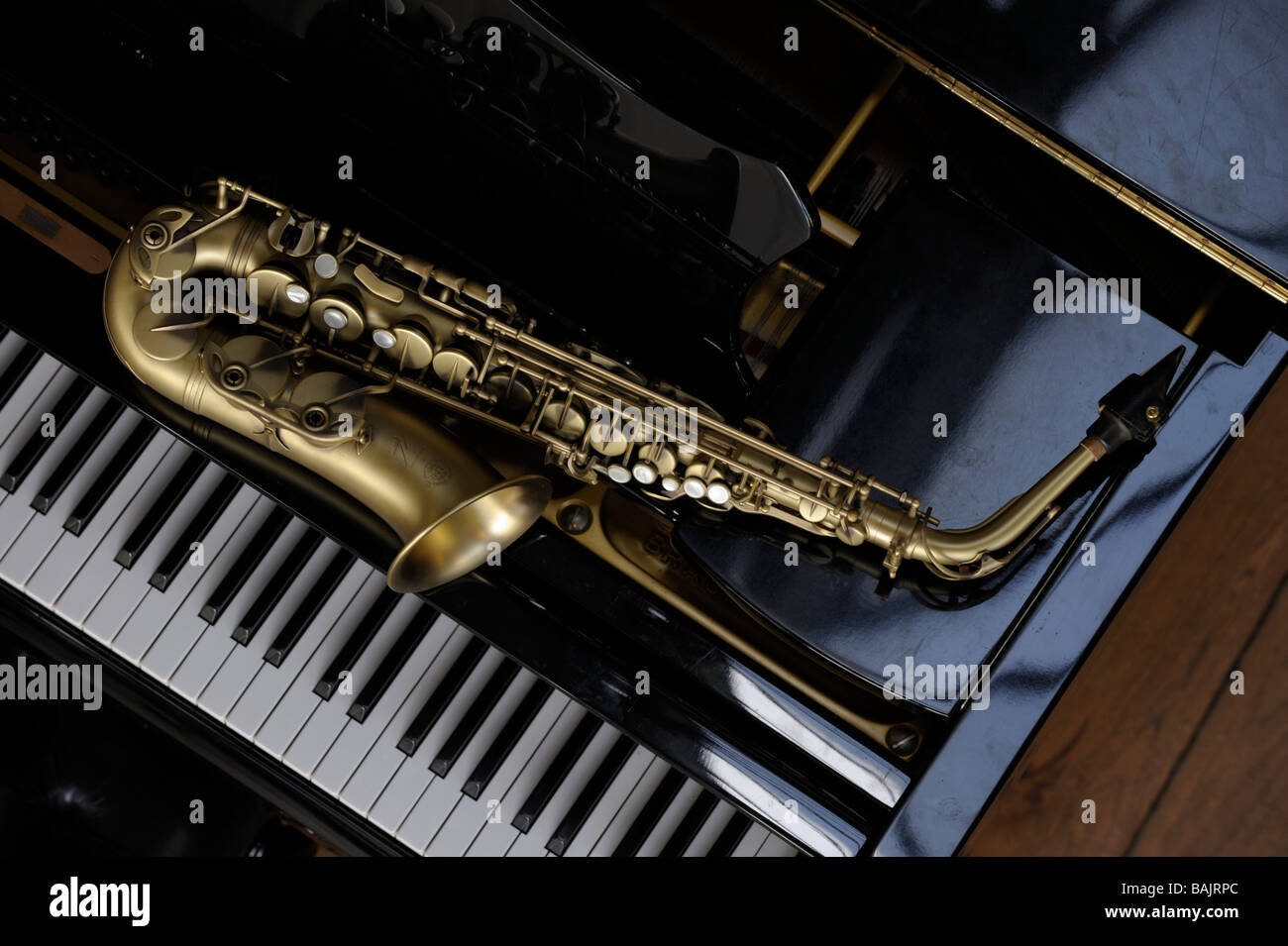 Saxophone Alto couché sur un grand piano Banque D'Images