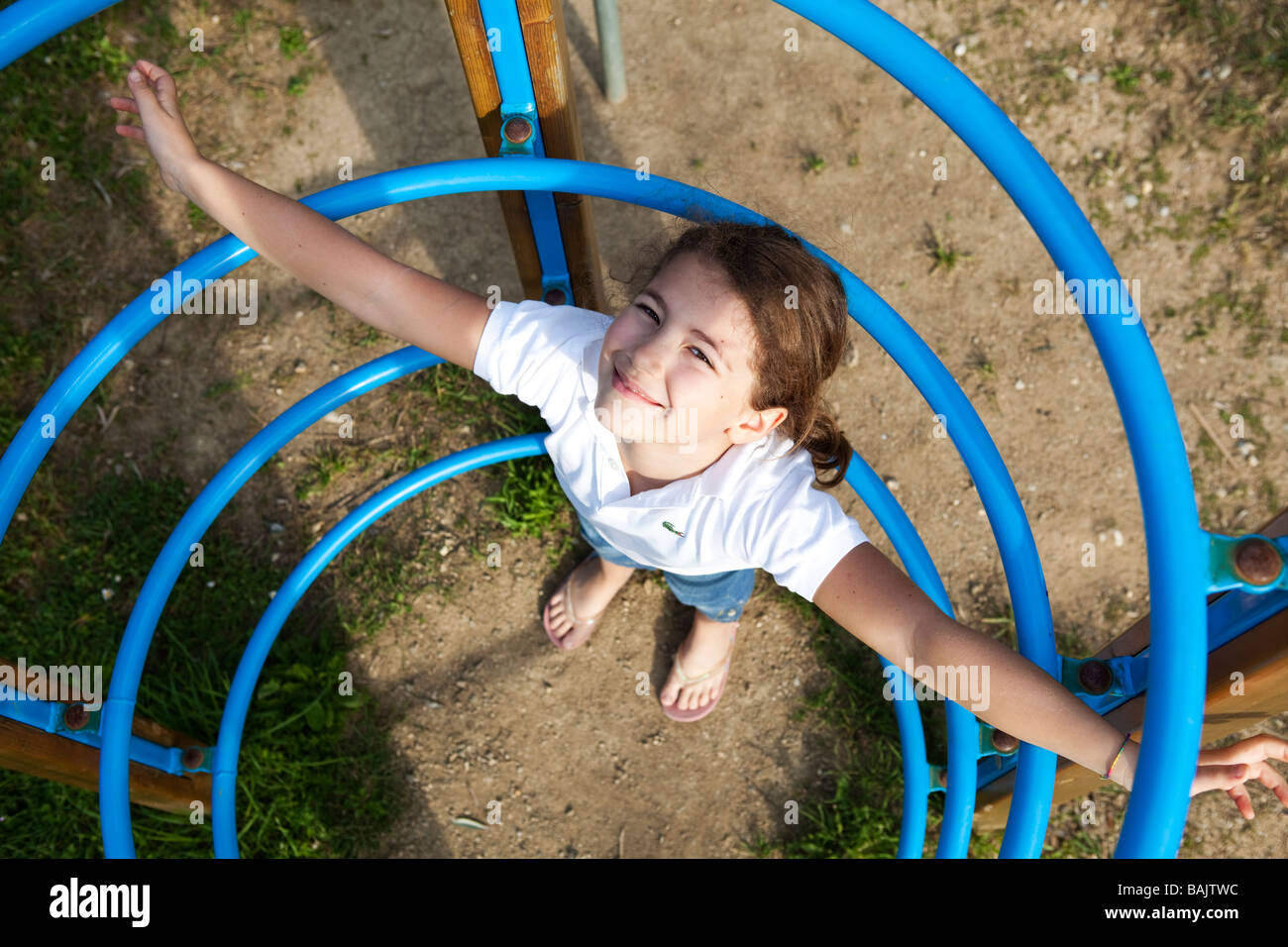 Enfant jouant seul dans les joints toriques à l'aire de jeux Banque D'Images
